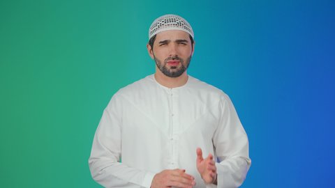 ضرورة الذهاب للطبيب والحصول على العلاج،الإنتفاخ والإلتهاب بالفم واللثة، مفهوم تسوس الأضراس, بورتريه لشاب عربي خليجي  اماراتي يرتدي الكندورة والقبعة البيضاء يضع يده على وجهه بإيماءات الألم ووجع الأسنان،  خلفية ملونة