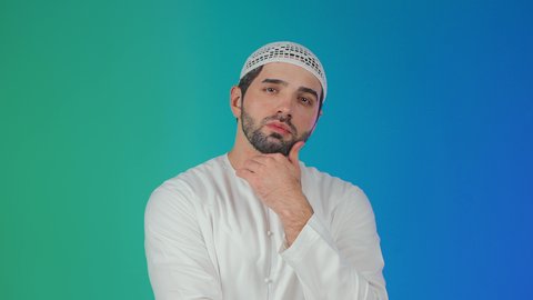 حل المشكلات واتخاذ القرارات، التطلع والتخطيط للمستقبل،بورتريه لرجل عربي خليجي اماراتي يرتدي الكندورة والقبعة البيضاء يضع يده على ذقنه بإيماءات التفكير وشرود الذهن، مفهوم الاستماع والتركيز، خلفية ملونة