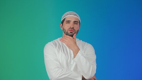 التطلع والتخطيط للمستقبل، حل المشكلات واتخاذ القرارات، بورتريه لرجل عربي خليجي اماراتي يرتدي الكندورة والقبعة البيضاء يضع يده على ذقنه بإيماءات التفكير وشرود الذهن، مفهوم الاستماع والتركيز، خلفية ملونة