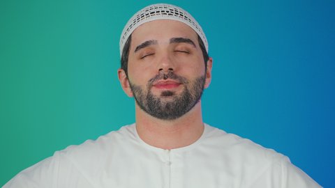 بورتريه لرجل عربي خليجي اماراتي يرتدي الكندورة والطاقيه يشير بيده بإيماءات وتعابير وجه و يدين تدل على الاعجاب، التعبير عن الجودة والاتقان، القبول والموافقة والرضا، علامة الجودة والامتياز،خلفية ملونة