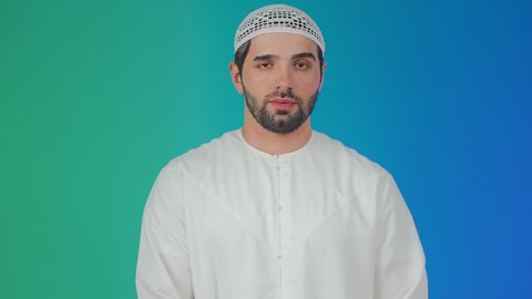 مفهوم الكسل والخمول، تعابير النعاس والحاجه الى النوم، بورتريه لرجل عربي خليجي اماراتي يرتدي الكندورة والطاقية يرفع يديه بإيماءات النعاس, الإحساس بالتعب والتثاؤب , خلفيه ملونة