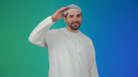 ايماءات السرور والسعادة, مفهوم السلام والترحيب, تعابير الوجه ولغة الجسد المختلفة, بورتريه لرجل  عربي اماراتي خليجي يرتدي الكندورة والطاقية يرفع اليد اليمني لإلقاء التحية,  خلفية ملونة