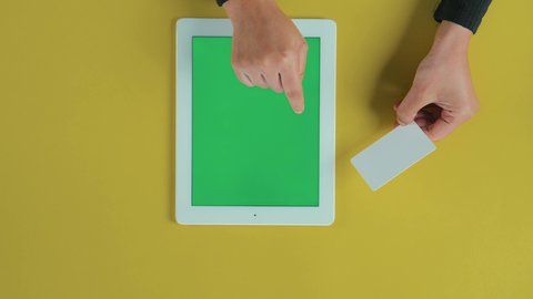 استخدام وسائل الدفع الحديثة، التسوق عبر المواقع الإلكترونية، تصفح برامج التواصل الاجتماعي، عرض شاشة خضراء فارغة على الأجهزة التقنية،تصوير مقرب  ليد امرأة عربية خليجية سعودية تستخدم التابلت و تحمل بطاقة الائتمان, كروما