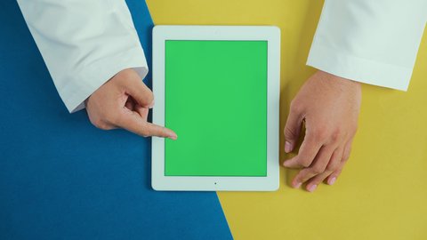 سحب الشاشة للأعلى, استخدام التكنولوجيا و التقنيات الحديثة، مفهوم إدارة المشاريع وانجاز المهام عن بعد، تصوير علوي عامودي ليد رجل عربي سعودي خليجي يرتدي الثوب التقليدي و يستخدم جهاز التابلت، تصفح مواقع و وسائل التواصل الاجتماعي, كروما