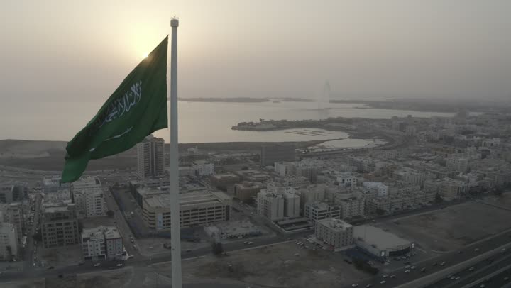 جمال مدينة جدة، راية التوحيد الخضراء ترفر في السماء، كورنيش جدة البحري، ميدان وشوارع ومعالم جدة المشهورة، تصوير درون لطريق الملك عبد الله المالي في مدينة جدة في المملكة العربية السعودية في وقت الغروب، حركة مرور السيارات، الابراج والمباني السكنية