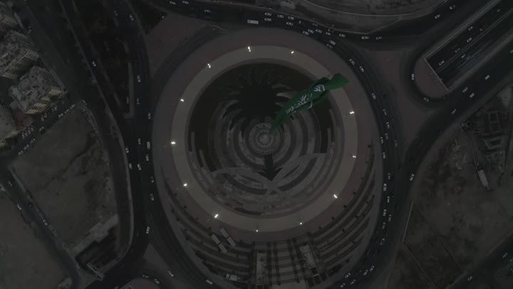 شوارع  وميدان ومعالم جدة المشهورة، جمال مدينة جدة، تصوير درون علوي لراية التوحيد الخضراء ترفر في السماء، كورنيش جدة البحري، طريق الملك عبد الله المالي في مدينة جدة في المملكة العربية السعودية في وقت المساء، حركة مرور السيارات، الابراج والمباني السكنية