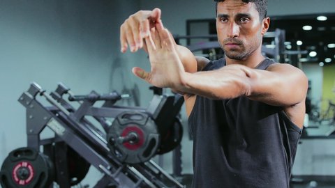 ممارسة الرياضة وبناء الكتلة العضلية للجسم، أسلوب الحياة الصحي، إيماءات الحماس و النشاط، المحافظة على التوازن الجسدي، تقوية العضلات ونحت الجسم، مفهوم الرشاقة واللياقة، شاب عربي خليجي سعودي يرتدي الملابس الرياضية يقوم بممارسة التمرينات الرياضية