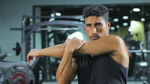 Gestures of enthusiasm and activity, maintaining physical balance, strengthening muscles and sculpting the body, the concept of agility and fitness, practicing exercises to tone the body, a healthy and beneficial lifestyle, a young Arab Gulf Saudi man wearing sportswear is exercising.