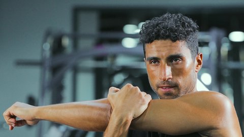 Maintaining physical balance, strengthening muscles and sculpting the body, the concept of agility and fitness, exercising to tone the body, a healthy and beneficial lifestyle, a young Arab Gulf Saudi man wearing sportswear practicing exercises, gestures of enthusiasm and activity.