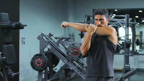 تقوية العضلات ونحت الجسم، مفهوم الرشاقة واللياقة، ممارسة التمارين لشد الجسد، نمط حياة صحي ومفيد، المحافظة على التوازن الجسدي، شاب عربي خليجي سعودي يرتدي الملابس الرياضية يقوم بممارسة التمرينات الرياضية ،إيماءات الحماس و النشاط