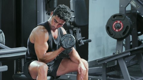 اتباع نظام صحي، التدرب على إتقان رفع الاوزان، مراقبة انقباض و انبساط العضلة، نشاط بدني للمحافظة على اللياقة الجسدية، شاب عربي خليجي سعودي يقوم بأداء التمارين باستخدام البار, رياضة كمال الأجسام، ايماءات القوة و الثقة