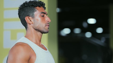 Practicing warm-up exercises, maintaining health and physical fitness, a young Arab Gulf Saudi man wearing sportswear walking on the treadmill, sports club, engaging in enjoyable recreational activities, using sports equipment.