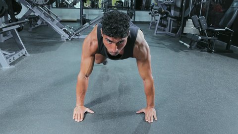 تمارين بدنية للشباب للحفاظ على الجسم صحيا، بناء عضلات الجسم وتقويتها, رياضة كمال الأجسام، شاب عربي خليجي سعودي يرتدي الزي الرياضي يقوم بممارسة التمارين الرياضية، أسلوب حياة صحي