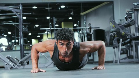 أنشطة رياضية لتحسين اللياقة للشباب، بناء عضلات الجسم وتقويتها, رياضة كمال الأجسام، شاب عربي خليجي سعودي يرتدي الزي الرياضي يقوم بممارسة التمارين الرياضية، أسلوب حياة صحي