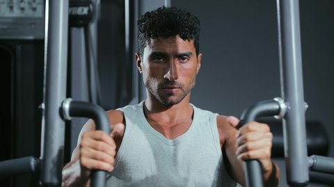 أهمية ممارسة الرياضة لبناء جسم صحي وقوي، تعزيز نشاط العضلات والأعصاب، أسلوب حياة صحي، استخدام الأجهزة الرياضية، شاب عربي خليجي سعودي يرتدي الزي الرياضي يقوم بممارسة تمرين تقوية عضلات الصدر و الذراعين و الكتفين على جهاز المتوازي