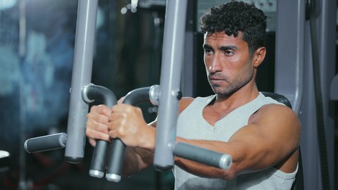 تقوية العضلات وتنشيط الأعصاب، أسلوب حياة صحي، استخدام الأجهزة الرياضية،أهمية الرياضة لبناء جسد قوي، شاب عربي خليجي سعودي يرتدي الزي الرياضي يقوم بممارسة تمرين تقوية عضلات الصدر و الذراعين و الكتفين على جهاز المتوازي