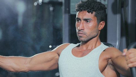 Supporting muscle and nerve health, a healthy lifestyle, using sports equipment, the importance of sports for building a strong body, a young Arab Gulf Saudi man wearing sportswear is performing an exercise to strengthen the chest, arms, and shoulders on the parallel bars.