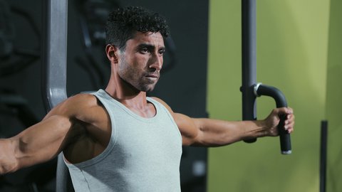 تقوية الأعصاب والعضلات، استخدام الأجهزة الرياضية،أهمية الرياضة لبناء جسد قوي، شاب عربي خليجي سعودي يرتدي الزي الرياضي يقوم بممارسة تمرين تقوية عضلات الصدر و الذراعين و الكتفين على جهاز المتوازي، أسلوب حياة صحي