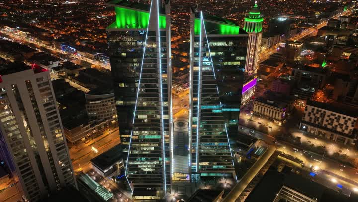 التطور والتقدم العمراني، نمط الحياة في العاصمة، طريق الملك فهد في المملكة العربية السعودية، الفن الهندسي المعماري للمباني وناطحات السحاب، تصوير درون لأبراج العليا في مدينة الرياض المضاءة في وقت الليل، الطرق والشوارع المعبدة