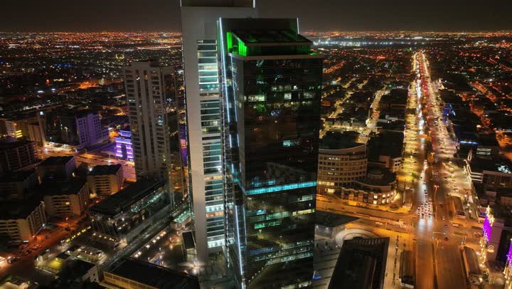 التطور والتقدم العمراني، نمط الحياة في العاصمة، طريق الملك فهد في المملكة العربية السعودية، الفن الهندسي المعماري للمباني وناطحات السحاب، تصوير درون لأبراج العليا في مدينة الرياض المضاءة في وقت الليل، الطرق والشوارع المعبدة