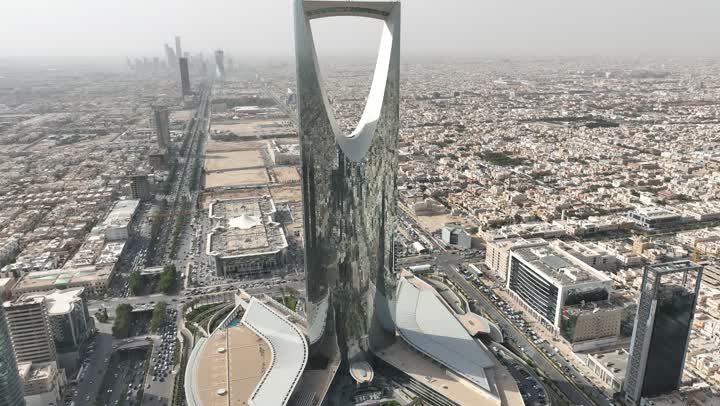 نمط الحياة في العاصمة، النمو والتطور والتقدم العمراني،  تصوير درون لبرج المملكة الشهير في وقت النهار، المباني والمعالم التجارية المشهورة في المملكة العربية السعودية، الفن الهندسي المعماري على الطراز المتطور والحديث للأبراج وناطحات السحاب في مدينة الرياض