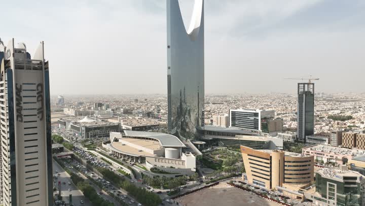 نمط الحياة في العاصمة، النمو والتطور والتقدم العمراني،  تصوير درون لبرج المملكة الشهير في وقت النهار، المباني والمعالم التجارية المشهورة في المملكة العربية السعودية، الفن الهندسي المعماري على الطراز المتطور والحديث للأبراج وناطحات السحاب في مدينة الرياض