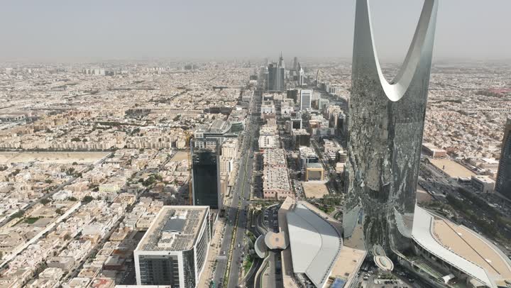 نمط الحياة في العاصمة، النمو والتطور والتقدم العمراني،  تصوير درون لبرج المملكة الشهير في وقت النهار، المباني والمعالم التجارية المشهورة في المملكة العربية السعودية، الفن الهندسي المعماري على الطراز المتطور والحديث للأبراج وناطحات السحاب في مدينة الرياض