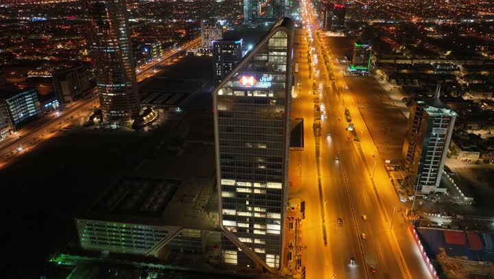 الفن الهندسي المعماري على الطراز المتطور للأبراج وناطحات السحاب في مدينة الرياض، نمط الحياة في العاصمة، النمو والتطور والتقدم العمراني،  تصوير درون لبرج بنك ساب في وقت الليل، المباني والمعالم التجارية المشهورة في المملكة العربية السعودية، طريق الملك فهد