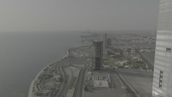 The view of the waterfront in the Kingdom of Saudi Arabia, drone photography of the Formula racing circuit on the Corniche of Jeddah, the architectural engineering art of towers and skyscrapers, the focus on planting green plants and palm trees in tourist areas, the natural landscapes in coastal cities.