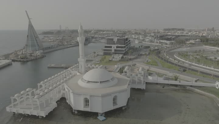 The view of the waterfront in the Kingdom of Saudi Arabia, drone photography of the Formula racing circuit on the Corniche of Jeddah, the architectural engineering art of towers and skyscrapers, the focus on planting green plants and palm trees in tourist areas, the natural landscapes in coastal cities.