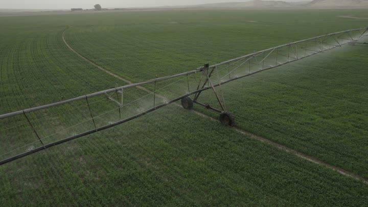 Irrigation machines and equipment in an agricultural field in the Kingdom of Saudi Arabia, agricultural lands and fields, caring for and attending to trees and green plants, drone photography of center pivot irrigation systems in agricultural fields, modern water sprinklers.