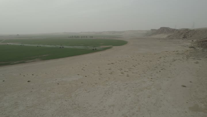 الات ومعدات الري في حقل زراعي بالمملكة العربية السعودية، الاراضي والحقول الزراعية، الاعتناء والاهتمام بالاشجار والنباتات الخضراء، تصوير درون لاذرع الري المحوري في الحقول الزراعية، الرشاشات الحديثة للمياه