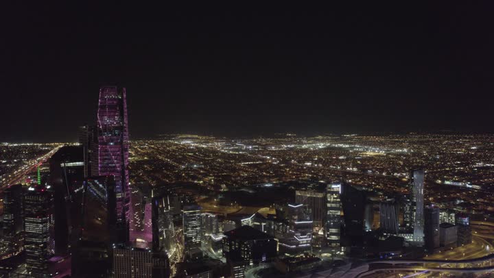 تحقيق النهضة الاقتصادية والتجارية، نمط الحياة في العاصمة، النمو والتطور العمراني في السعودية، تصوير درون للمنشآت والأبراج المالية في مدينة الرياض المضاءة في وقت الليل، الفن الهندسي المعماري للمباني وناطحات السحاب المشهورة في المملكة