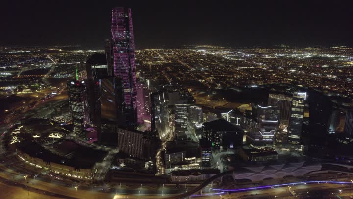 تحقيق النهضة الاقتصادية والتجارية، نمط الحياة في العاصمة، النمو والتطور العمراني في السعودية، تصوير درون للمنشآت والأبراج المالية في مدينة الرياض المضاءة في وقت الليل، الفن الهندسي المعماري للمباني وناطحات السحاب المشهورة في المملكة