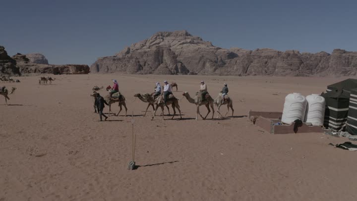 Outdoor camping and youth camping, interest in raising camels and dromedaries, drone photography for camel safari trips in the middle of the kingdom's desert, sand dunes and desert areas, the concept of livestock and mammal care, natural landscapes in deserts, mountain and rock formations.