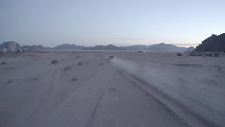 The use of modern vehicles for fast land transportation, driving on rough roads and sand dunes, traveling through the deserts of Saudi Arabia, means of transportation and communication, the desert nature and dry environment, drone photography for adventures and safari trips in the Al-Ula desert.