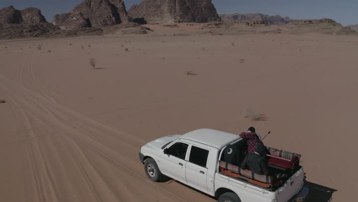 The use of modern vehicles for fast land transportation, driving on rough roads and sand dunes, traveling through the deserts of Saudi Arabia, means of transportation and communication, the desert nature and dry environment, drone photography for adventures and safari trips in the Al-Ula desert.