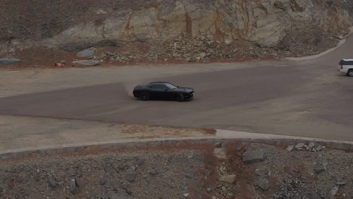 Safari adventures on the sand dunes, drone footage of driving a Dodge car in the desert, fun desert activities, an exciting adventure on the soft golden sands in the deserts of Saudi Arabia, enjoying practicing favorite hobbies, the movement of the car wheels.