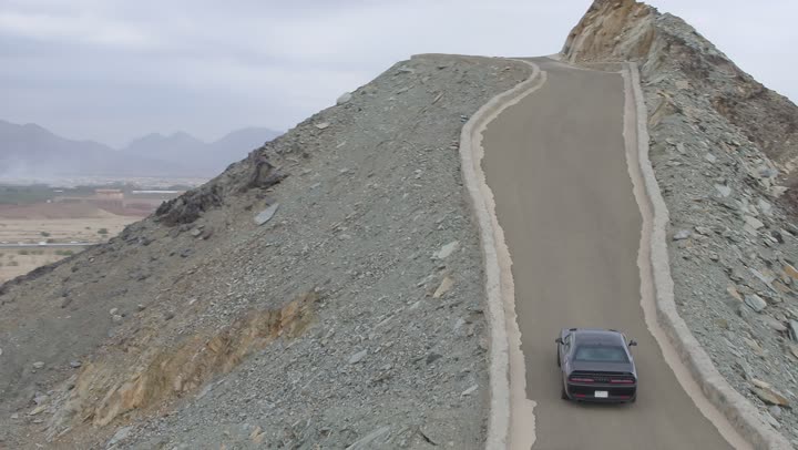 Safari adventures on the sand dunes, drone footage of driving a Dodge car in the desert, fun desert activities, an exciting adventure on the soft golden sands in the deserts of Saudi Arabia, enjoying practicing favorite hobbies, the movement of the car wheels.