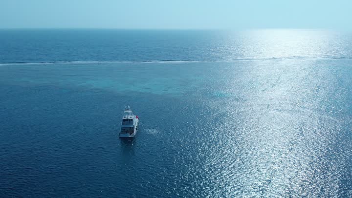 مناطق سياحية مشهورة، الأمواج المتلاطمة في عرض مياه البحر الأحمر في المملكة العربية السعودية، الاستمتاع على الشواطئ الساحلية، الأمواج البحرية الهادئة، الأماكن والمعالم السياحية الساحلية المشهورة، تصوير درون جوي لحركة السفن وسط البحر الأحمر، المناظر الطبيعية المتميزة