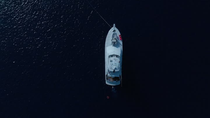 In the middle of the Red Sea, ships sail, enjoyment on the coastal beaches, distinctive landscapes, famous tourist areas, drone footage of the calm waves in the waters of the Red Sea in Saudi Arabia at night, famous coastal places and landmarks.