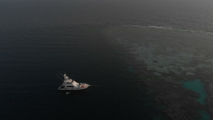 السفن وسط البحر الأحمر، المتعة على الشواطئ الساحلية، المناظر الطبيعية المتميزة، مناطق سياحية مشهورة، تصوير درون للأمواج الهادئة في عرض مياه البحر الأحمر في المملكة العربية السعودية في الليل، الأماكن والمعالم السياحية الساحلية المشهورة