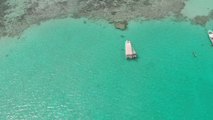 Enjoyment on the coastal beaches, distinctive landscapes, famous tourist areas, the calm waves in the waters of the Red Sea in the Kingdom of Saudi Arabia, the famous coastal places and landmarks, aerial drone photography of a man spending time on a ship in the middle of the Red Sea.