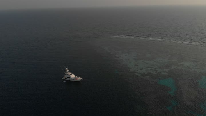 السفن وسط البحر الأحمر، المتعة على الشواطئ الساحلية، المناظر الطبيعية المتميزة، مناطق سياحية مشهورة، تصوير درون للأمواج الهادئة في عرض مياه البحر الأحمر في المملكة العربية السعودية في الليل، الأماكن والمعالم السياحية الساحلية المشهورة