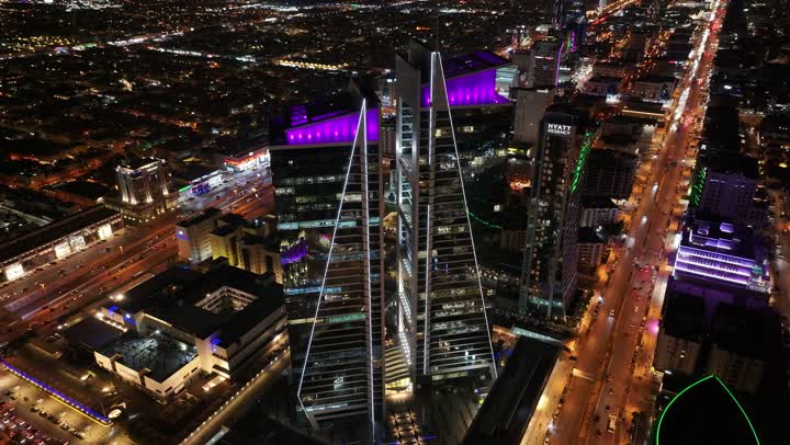 معالم سياحية مشهورة في العاصمة، ابراج ومعالم الرياض المشهورة، حركة مرور السيارات في طرق وشوارع مدينة الرياض في المملكة العربية السعودية، تصوير درون لابراج وناطحات السحاب المضيئة في الليل، الفن الهندسي المعماري