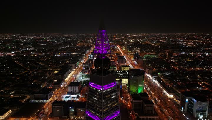 معالم سياحية مشهورة في العاصمة، ابراج ومعالم الرياض المشهورة، تصوير درون لبرج الفيصلية المضيء ليلا، حركة مرور السيارات في طرق وشوارع مدينة الرياض في المملكة العربية السعودية، الابراج وناطحات السحاب المضيئة في الليل، الفن الهندسي المعماري