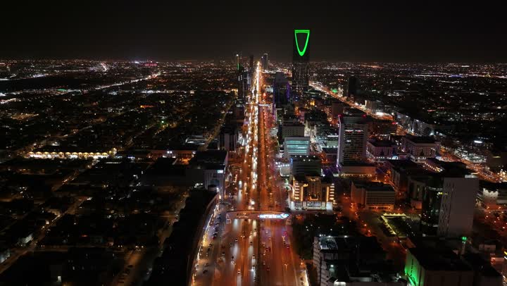 Famous towers and landmarks of Riyadh, drone footage of the illuminated Kingdom Tower at night, traffic of cars on the roads and streets of Riyadh city in the Kingdom of Saudi Arabia, illuminated towers and skyscrapers at night, architectural engineering art, famous tourist attractions in the capital.