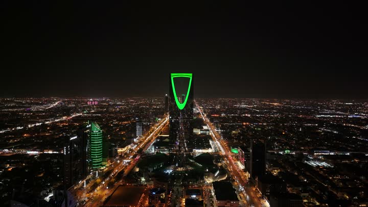 ابراج ومعالم الرياض المشهورة، تصوير درون لبرج المملكة المضيء ليلا، حركة مرور السيارات في طرق وشوارع مدينة الرياض في المملكة العربية السعودية، الابراج وناطحات السحاب المضيئة في الليل، الفن الهندسي المعماري، معالم سياحية مشهورة في العاصمة،