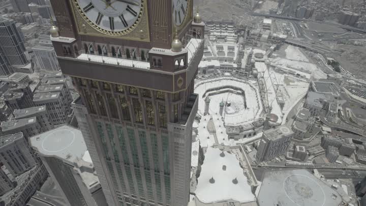 مقصد المسلمين من مختلف البلدان، في مكة المكرمة برج الساعة، مكان ومعلم ديني مقدس في المملكة العربية السعودية, تصوير درون جوي مقرب للفن الهندسي المعماري للأبراج وناطحات السحاب، التقدم والنمو العمراني للفنادق والمباني المطلة على الحرم المكي الشريف