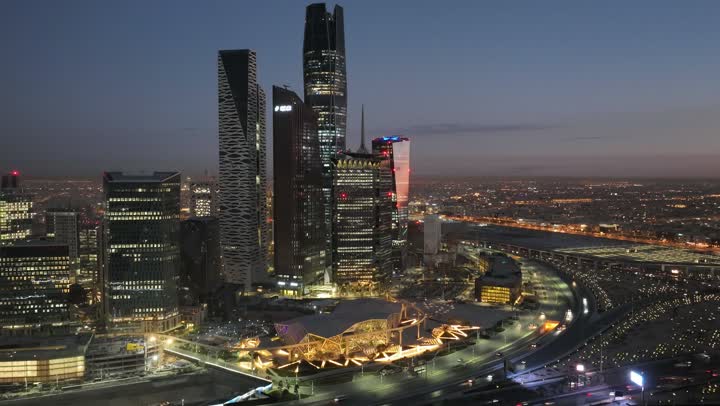 النمو والتطور العمراني للفنادق وناطحات السحاب في المملكة العربية السعودية، الفن الهندسي المعماري للأبراج المالية والمنشآت الاقتصادية المضاءة في الليل في العاصمة، تصوير درون ليلي لمدينة الملك عبدالله الاقتصادية (كافيد)، معالم التجارة المشهورة